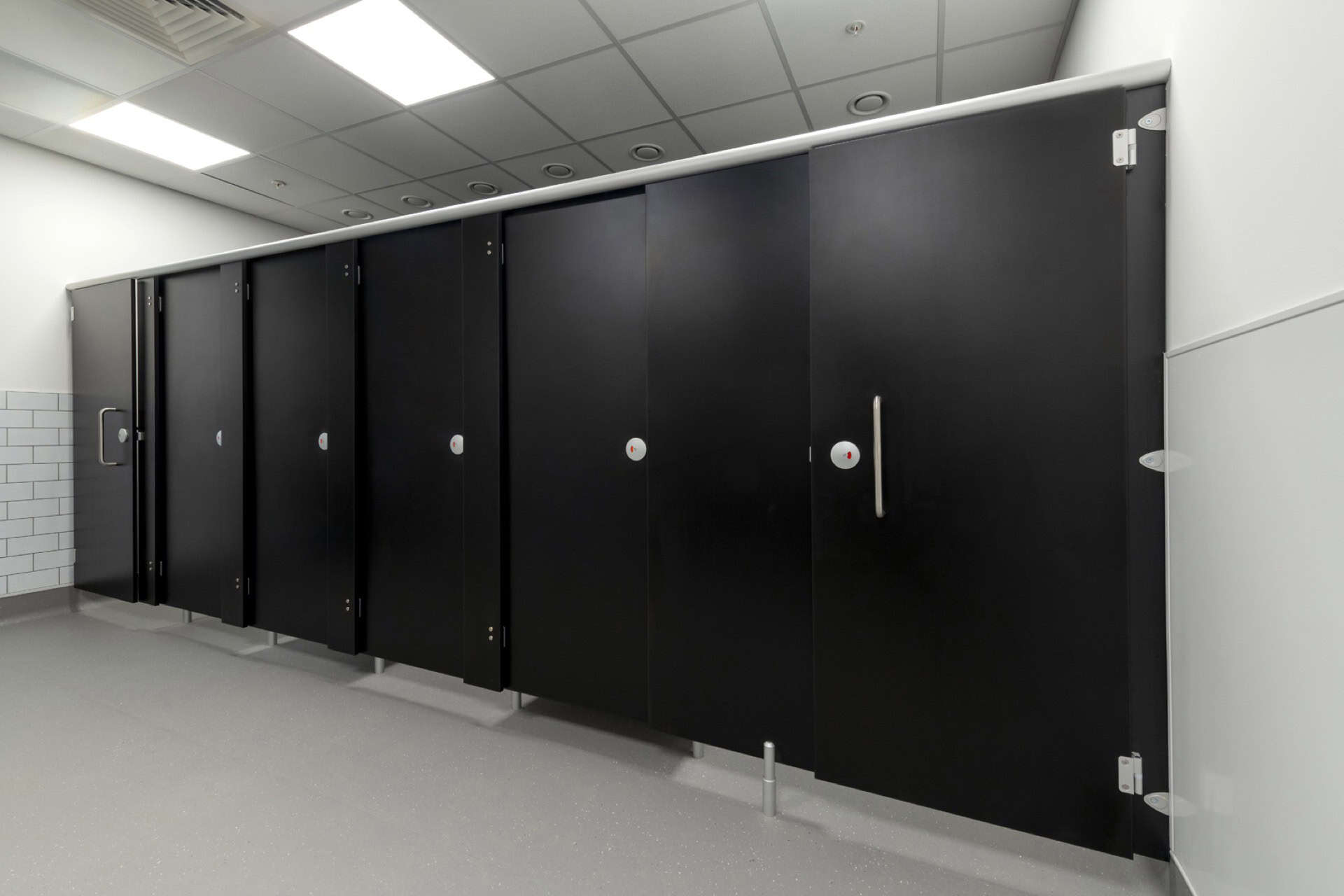 Row of 5 force cubicles in a washroom.