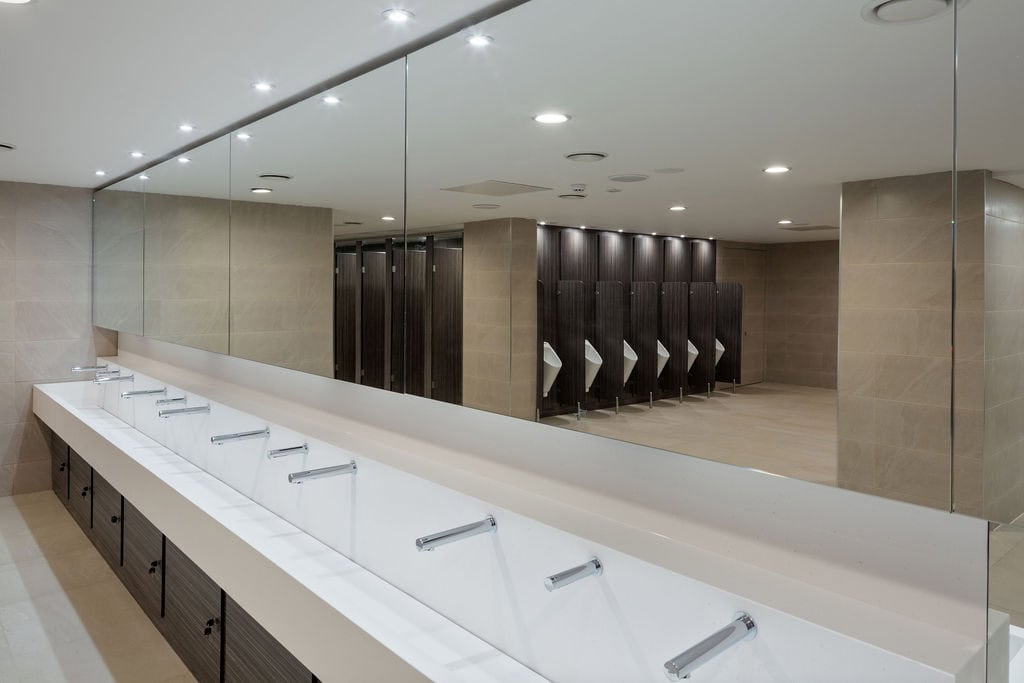 White Solid Surface Wash Trough with woodgrain underpanels in an industrial washroom