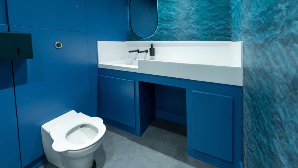 Bespoke Solid Surface Vanity with a baby change area in a children's play centre with blue underpanels