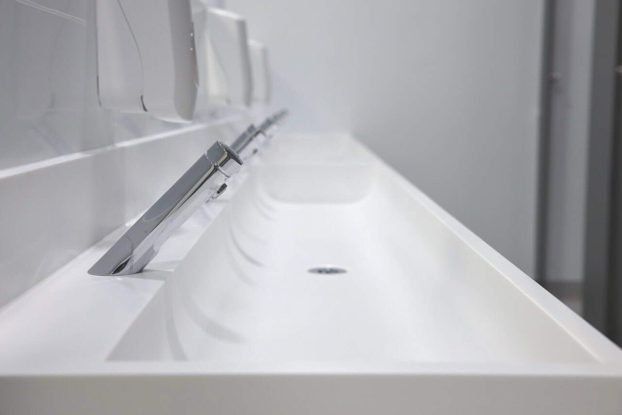White solid surface wash trough in a school washroom by Concept Washroom