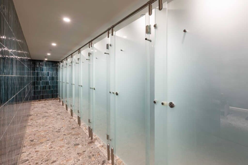 Modern washroom cubicles with frosted glass doors at London Bridge studio.