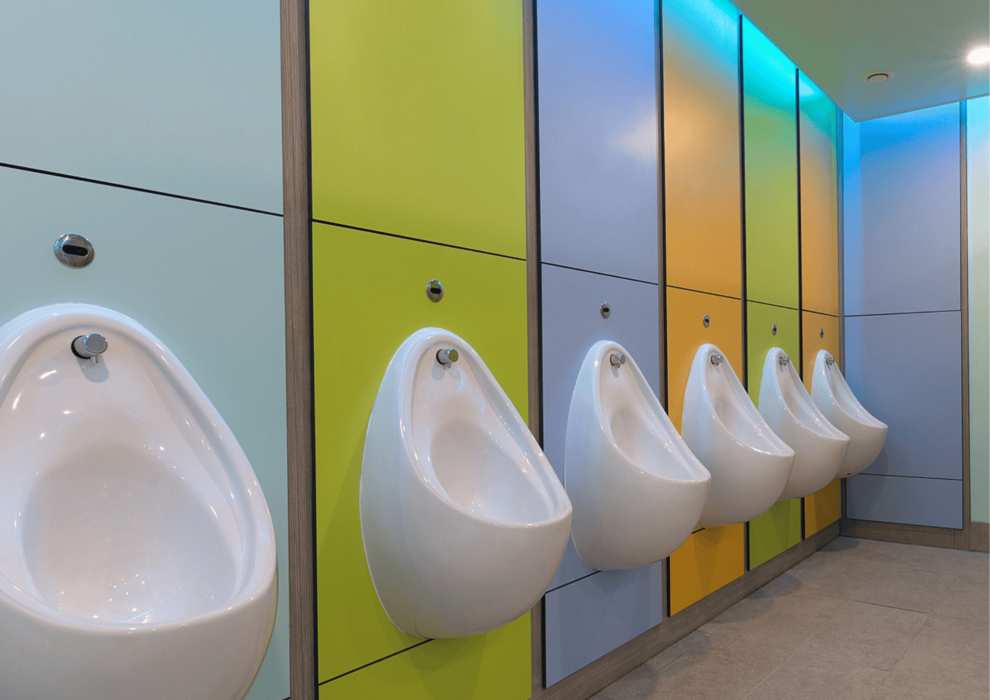 Urinals in a vibrant, contemporary washroom with colourful cubicle panels.