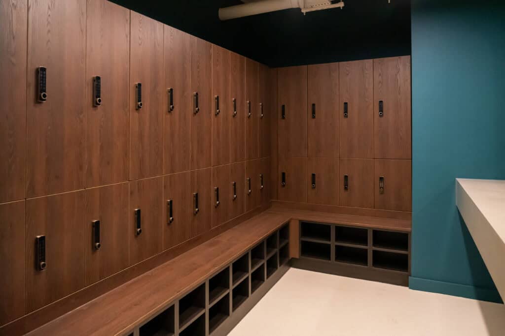Wooden lockers with digital locks in a contemporary locker room.